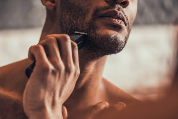 Close up. Afro-American Man Shaving in Bathroom. stock photo
