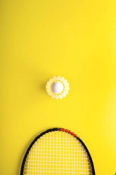 istock Shuttlecock and racket for playing badminton on a yellow background. Minimalism. Concept summer razlecheny 994713374
