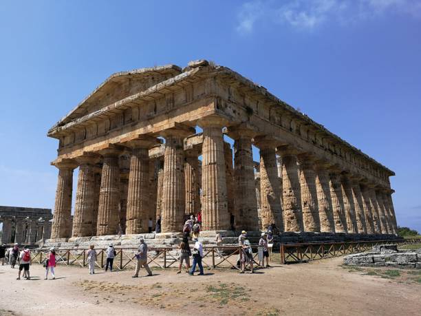 Paestum - Tourists at the Temple of Neptune Paestum, Salerno, Campania, Italy - July 1, 2018: Tourists at the Temple of Neptune in the Archaeological Park of Paestum temple of neptune doric campania italy stock pictures, royalty-free photos & images