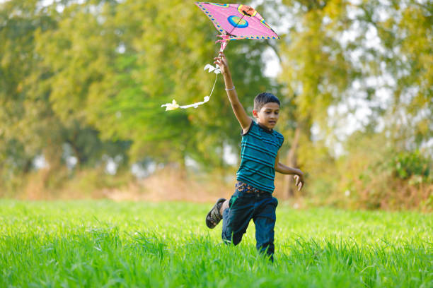 istock indian child playing with kite 994735602