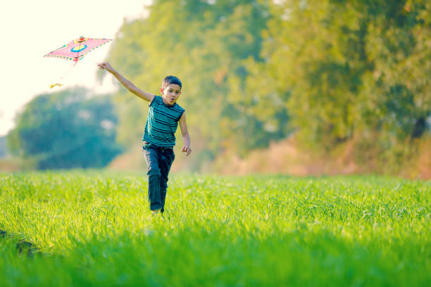 istock indian child playing with kite 994735660