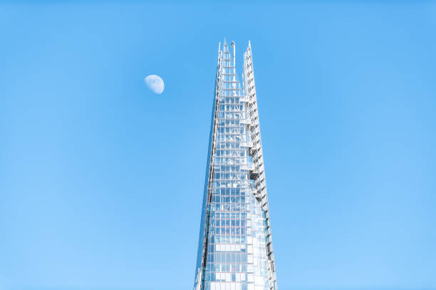 Isolated closeup of modern tall skyscraper glass window Shard building in downtown center city with blue sky and moon London, UK - June 22, 2018: Isolated closeup of modern tall skyscraper glass window Shard building in downtown center city with blue sky and moon the shard close up stock pictures, royalty-free photos & images
