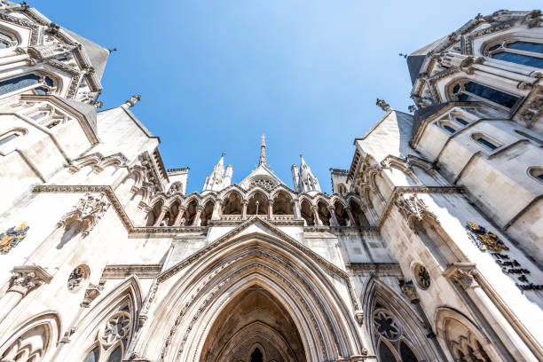 royal courts of justice wide angle exterior architecture with sign closeup, nobody, isolated blue sky in center of downtown district city - british culture elegance london england english culture imagens e fotografias de stock