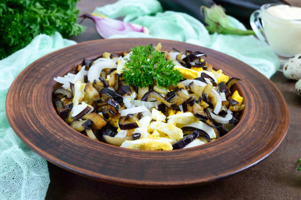 istock Spicy salad of fried eggplant, boiled egg, marinated onions in a bowl. 994753888