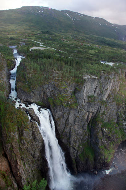 istock A tall beautiful waterfall falls into a dark gorge, at the top are low mountains 994756456
