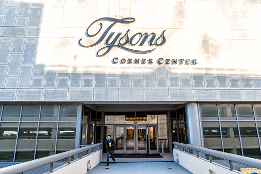 Tysons, USA - January 26, 2018: Sign, entrance doors on bridge to Tyson's Corner Mall in Fairfax, Virginia by Mclean with people walking