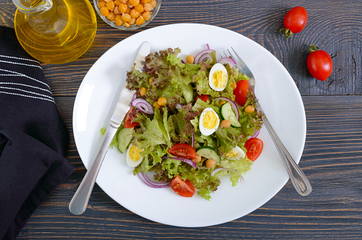 Light summer salad with fresh vegetables, greens, quail eggs and chickpeas. Vegetarian dish. Proper nutrition. Top view.