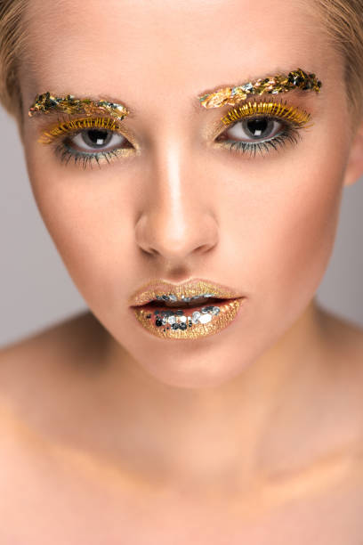 istock attractive woman with golden glitter on face looking at camera 994758902