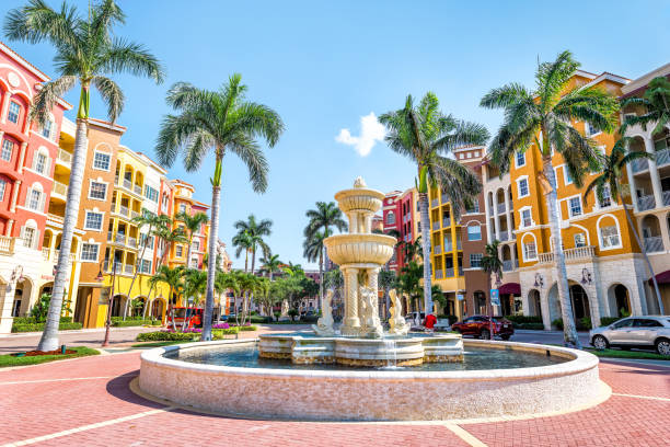 condomini bayfront, condomini colorati, multicolori, edifici multicolori con fontana, acqua, palme, cielo blu nella comunità residenziale - naples florida foto e immagini stock