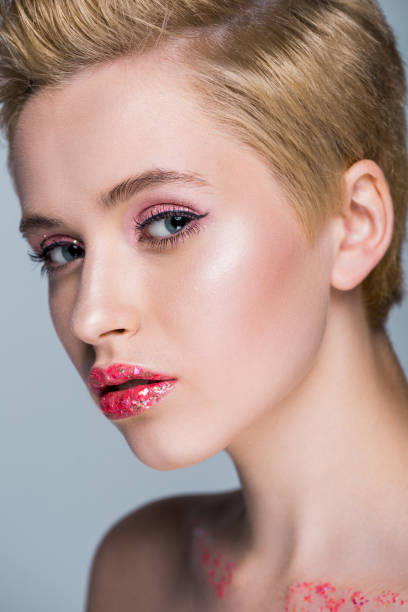 istock attractive woman with red lips with glitter looking at camera isolated on grey 994761702