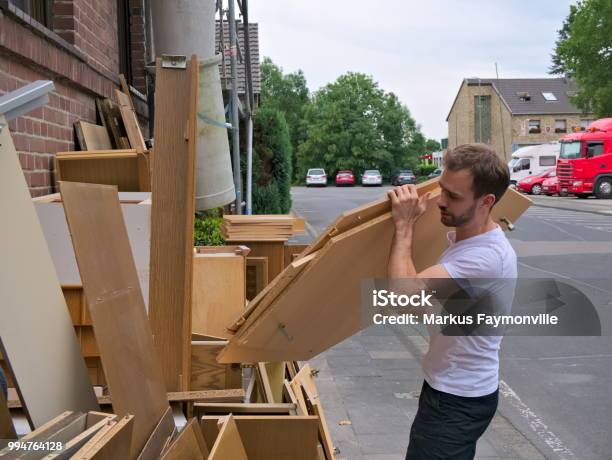 Young Man Cleaning Out Bulky Waste On Sidewalk Stock Photo - Download Image Now - Garbage, Wood - Material, Large