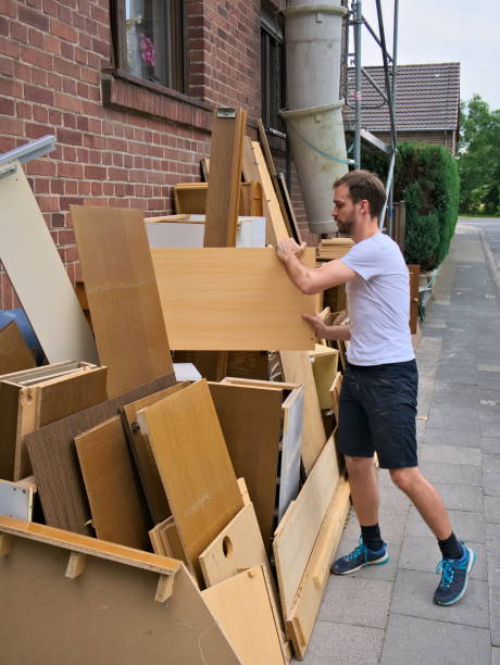 istock Young man cleaning out bulky waste on sidewalk 994764130