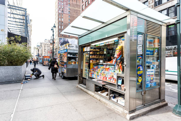 Midtown Manhattan with street sidewalk on Broadway, Newsstand with newspaper, magazines, candy New York City, USA - April 7, 2018: Midtown Manhattan with street sidewalk on Broadway, Newsstand with newspaper, magazines, candy news stand stock pictures, royalty-free photos & images