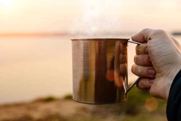 istock a man s hand holding a metal mug 994775464