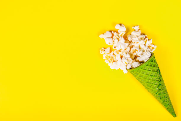 istock Green waffle cone on a yellow background. Yellow paper background and sweets. 994786614