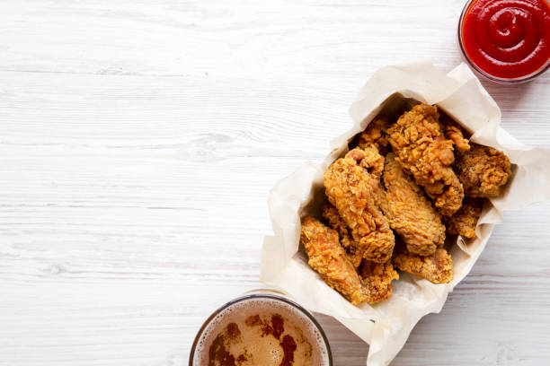 istock Fried chicken wings with red pepper sauce, cold beer, top view. Flat lay, overhead. Copy space. 994792446