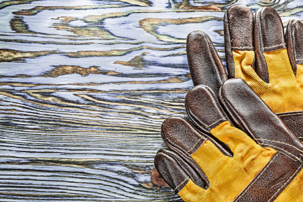 istock Pair of working gloves on wooden board 994798208