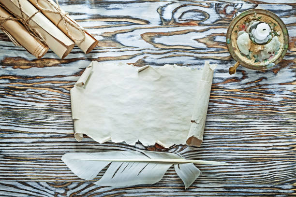 istock Vintage paper scrolls feather candlestick candle on wooden board 994798672
