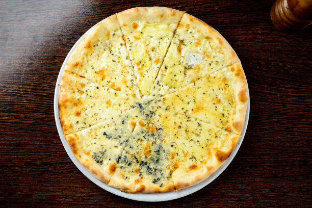 four cheese pizza, italian pizza. pizza stuffed with four varieties of cheese on a gray background
