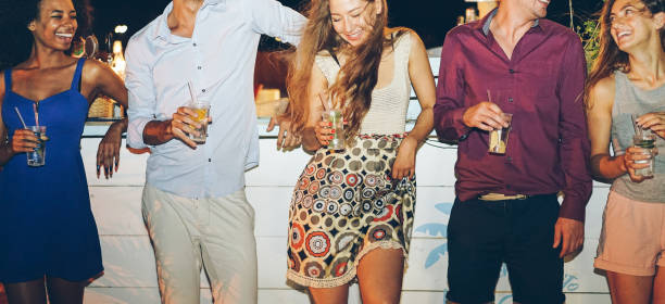 Happy friends drinking cocktails at beach party outdoor - Young millennials people having fun at weekend summer night lounge club - Youth lifestyle and nightlife concept - Main focus on center girl amigos felices bebiendo cócteles en fiesta de playa al aire libre - gente joven milenio divertirse en fin de semana verano noche lounge club - concepto de estilo de vida y la vida nocturna de la juventud - principal enfocado chica centro