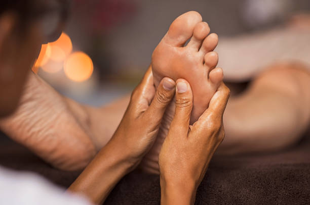 massage de réflexologie des pieds - reflexology pedicure massaging human foot photos et images de collection
