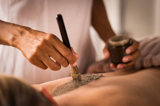 esteticista aplicando a lama no corpo - mud spa treatment health spa massaging - fotografias e filmes do acervo