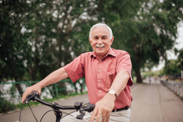 istock Senior man riding a bicycle and smiling 994820048