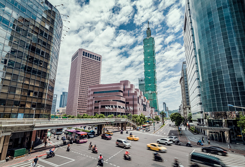 Motorbikes and traffic on the road with landmark supertall skyscraper in Xinyi District-Dan, Taipei, Taiwan