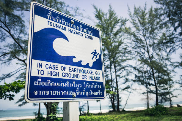 Tsunami earthquake disaster evacuation warning sign A Tsunami Hazard Zone warning sign near the waters edge in Koh Lanta, Thailand.  The instruction being in case of Tsunami or earthquake, go to high ground or inland.  These advisory evacuation signs were erected following the Indian Ocean Tsunami on 26 December 2004, where 230,000 people were killed in 14 countries.  They are written in Thai and English and are common place throughout coastal areas. 2004 indian ocean earthquake and tsunami stock pictures, royalty-free photos & images