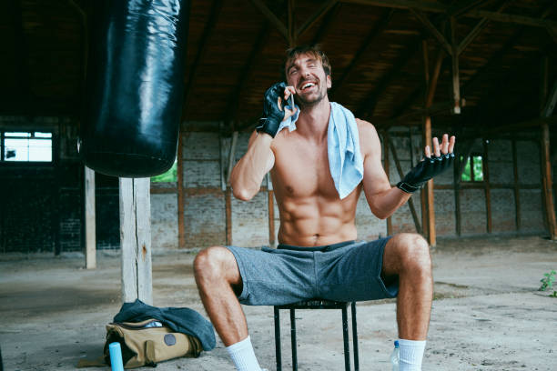 istock smiling man resting and talking on the phone after finished training 994823636