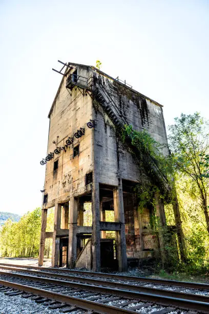 Abandoned retro vintage concrete loading receiving terminal building exterior in Thurmond, West Virginia ghost town with decaying structure walls, windows, railroad