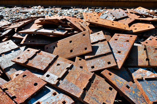 pile of scrap rail railway railroad track rusty grungy metal plates covered in rust, abandoned in junk yard with grunge - railroad spikes imagens e fotografias de stock