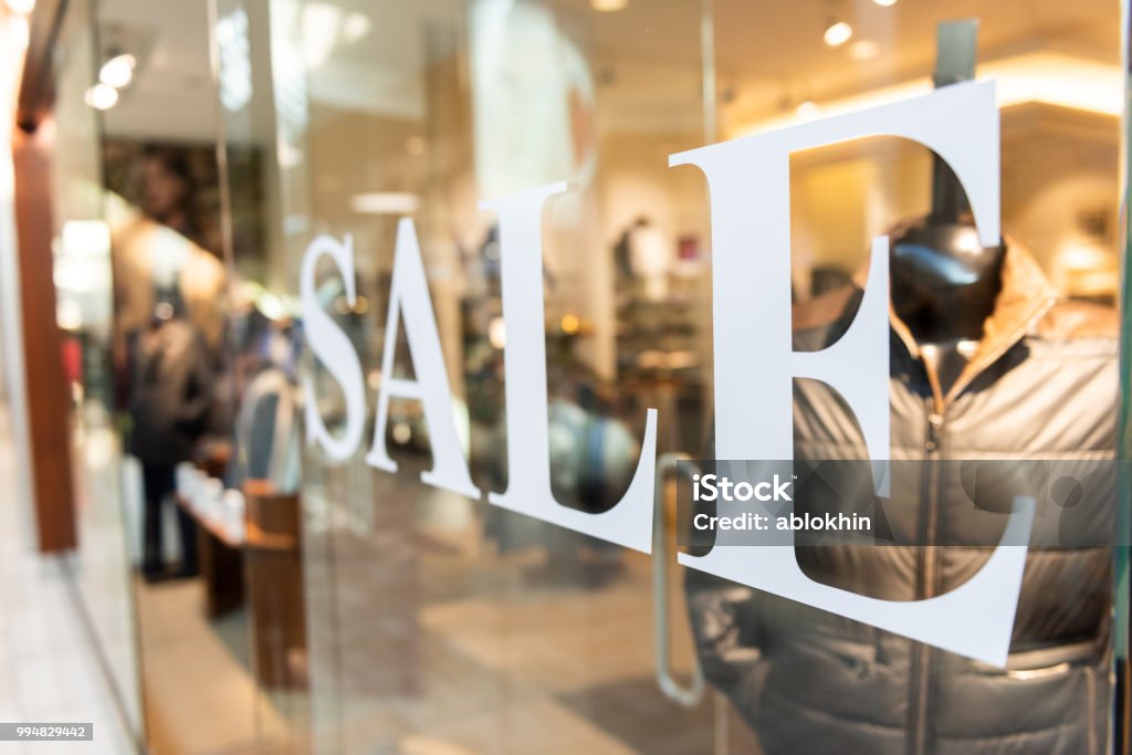 Closeup of Sale sign on clothes, clothing, apparel retail store, shop window in shopping mall Sale Stock Photo