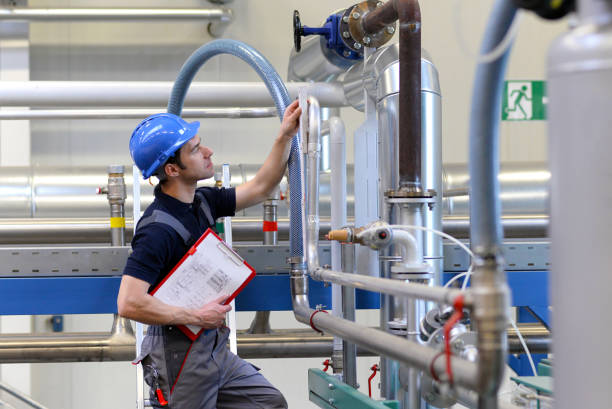 istock industrial workers inspect the technology of a plant for function - assembler in working clothes 994834692
