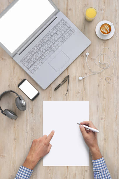 istock Man writing on a blank piece of paper, copy space template - top view 994842262