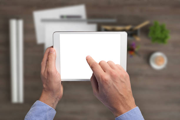 istock Man holding tablet knolling overhead view 994842296