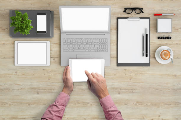 istock Man holding tablet knolling overhead view 994842330