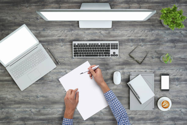 istock Man writing on a blank piece of paper, copy space template - top view 994842354