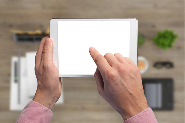 istock Man holding tablet knolling overhead view 994842372