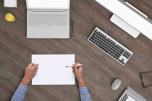 istock Man writing on a blank piece of paper, copy space template - top view 994842402