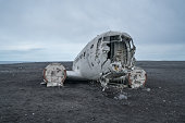 Airplane wreck on beach Iceland against dramatic sky, DC3 navy plane