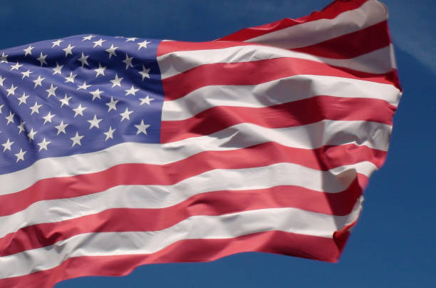 istock American Flag Flag Waving Against Beautiful Summer Blue Sky 994856888