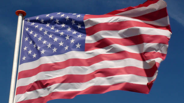 istock American Flag Flag Waving Against Beautiful Summer Sky 994857180