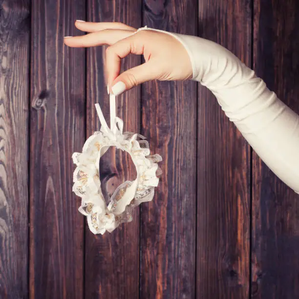 bride holding a garter against wooden background