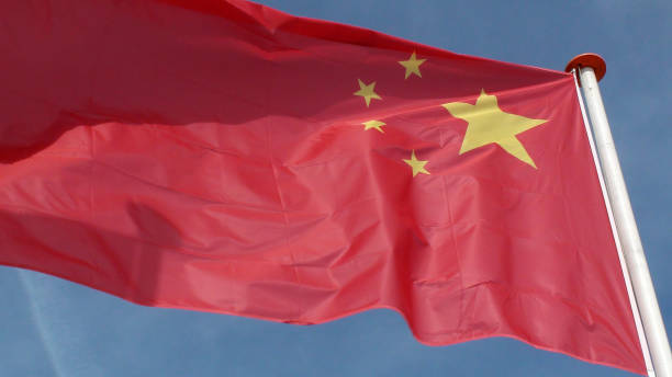 istock Chinese National Flag Waving Against Blue Sky 994857366