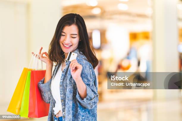 Glücklich Schöne Asiatische Frau Lächeln Auf Kreditkarte Halten Einkaufstaschen Textfreiraum Auf Shoppingmallhintergrund Shopaholic Menschen Reiches Mädchen Taschengeld Lebensstil Oder Kaufhaus Zahlung Konzept Stockfoto und mehr Bilder von Einkaufen