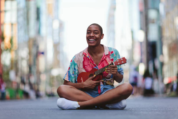 istock Young woman playing ukulele in street 994866394