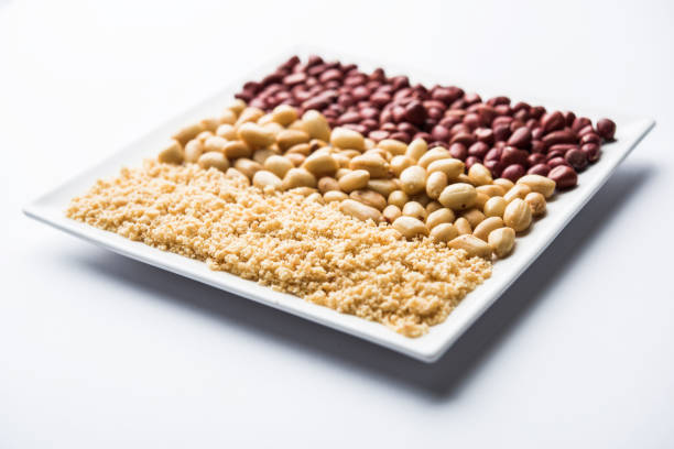 Crushed peanuts or mungfali powder with whole and roasted groundnut. Served in a bowl over moody background. Selective focus