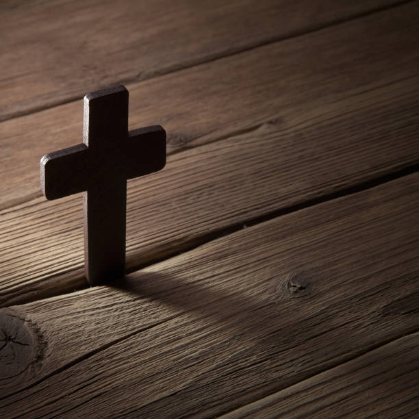 istock wooden cross on wood background 994872946