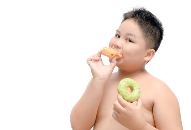 istock Obese fat boy is eating donut isolated 994884992